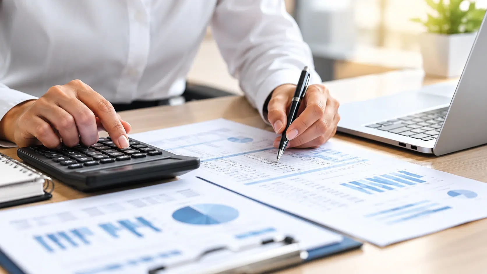 Australia 2 Accounting professional reviewing financial reports with a calculator and laptop for business finance support.